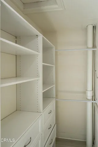 a view of walk in closet with empty racks