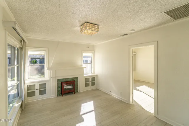 a view of a livingroom with wooden floor and a fireplace