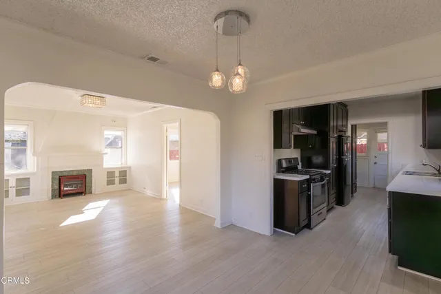 a view of a livingroom with a kitchen and a stove wooden floor kitchen view