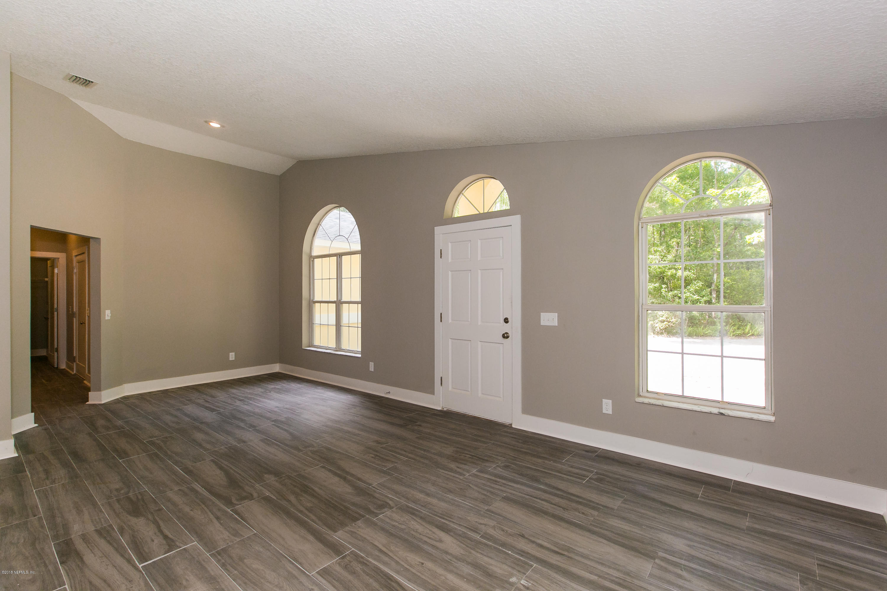 2225 Pacetti Road St. Augustine, FL 32092 - Photo 7 of 42 an empty room with wooden floor and windows