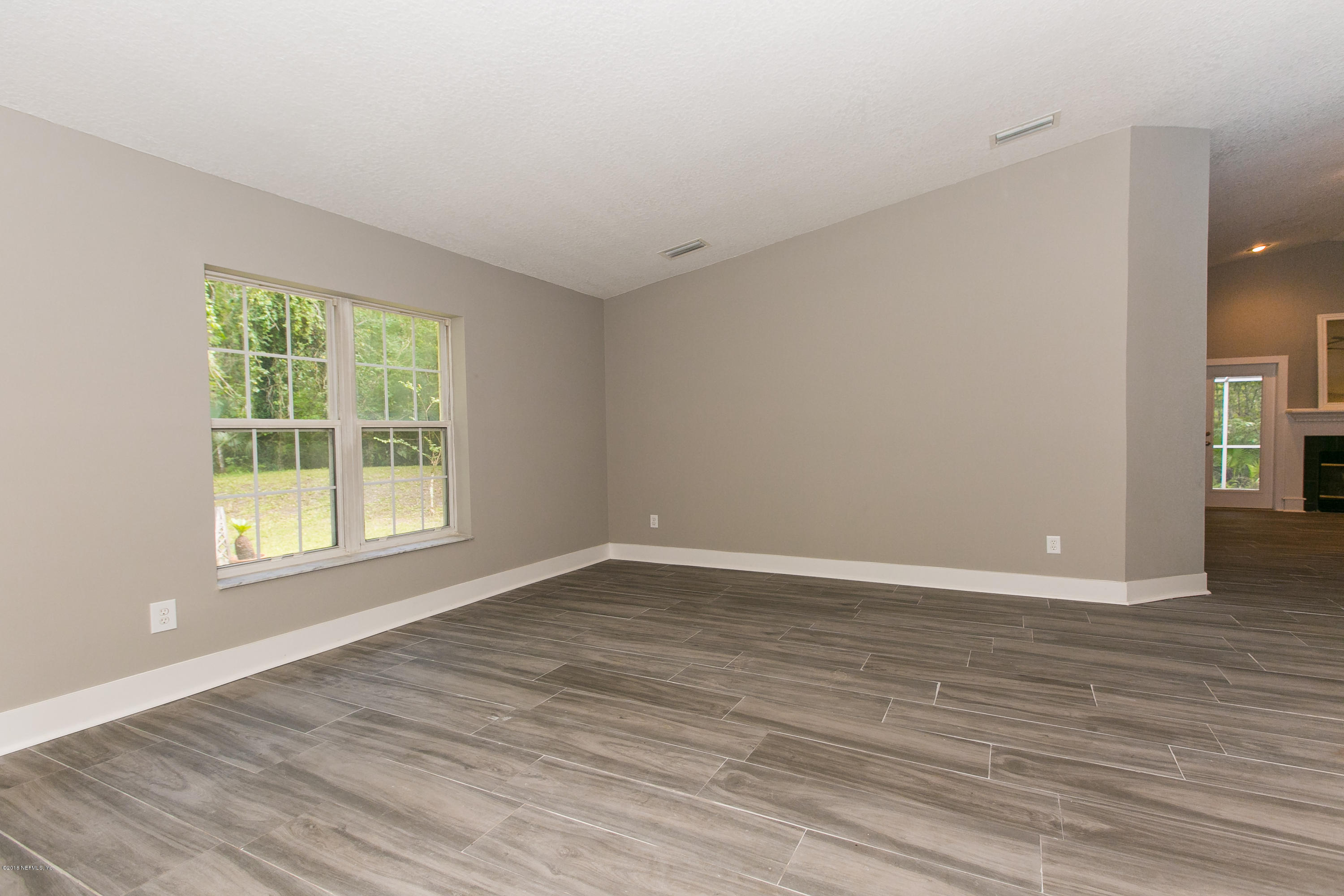 2225 Pacetti Road St. Augustine, FL 32092 - Photo 8 of 42 a view of an empty room with wooden floor and a window