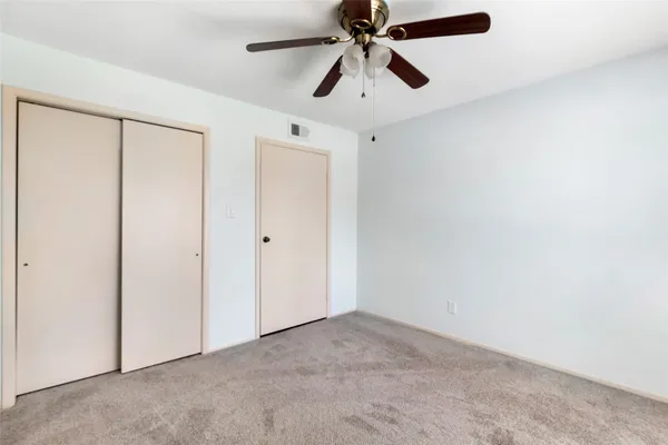 an empty room with chandelier fan