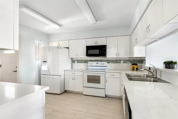a kitchen with white cabinets and stainless steel appliances