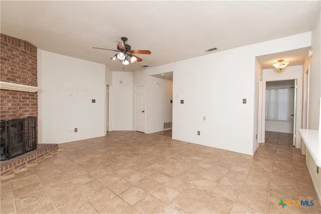 a view of a big room with chandelier fan and a fireplace