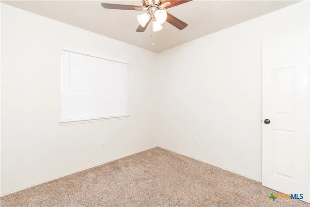 a view of a room with a ceiling fan and a window
