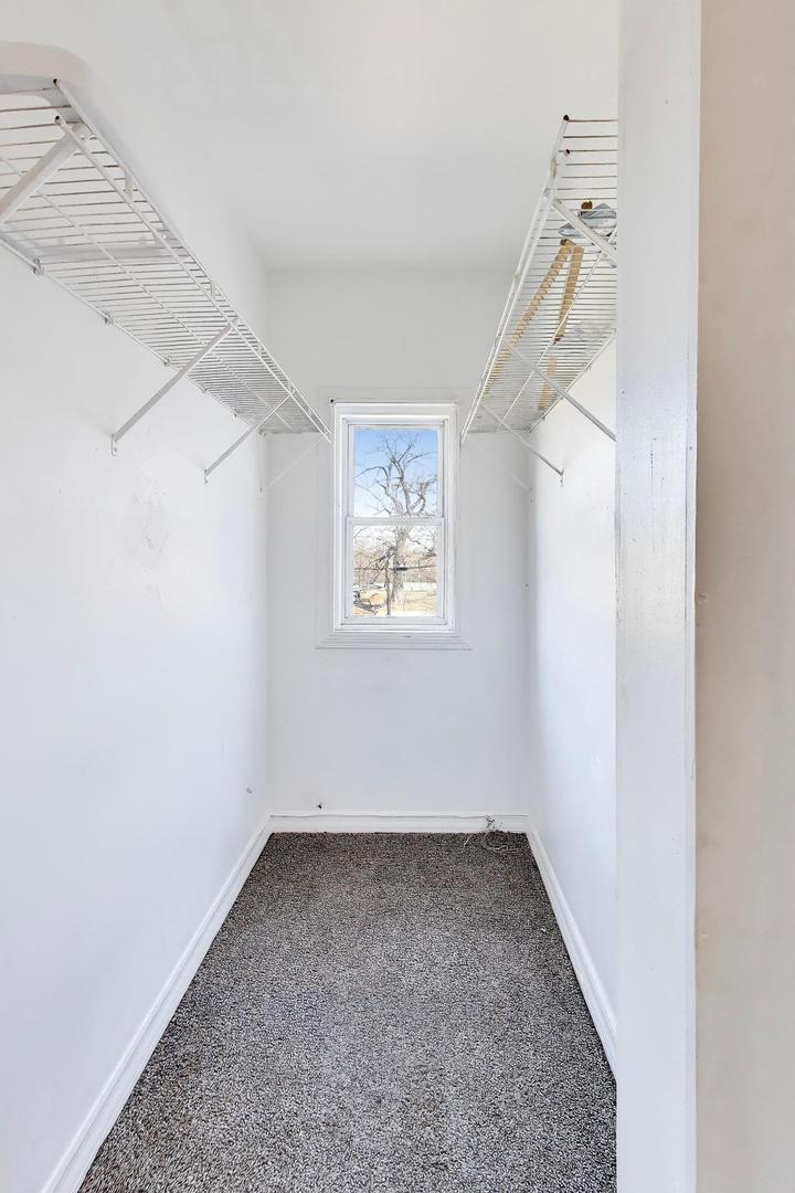 6853 South Perry Avenue Chicago, IL 60621 - Photo 21 of 28 an empty room with a hallway and a window