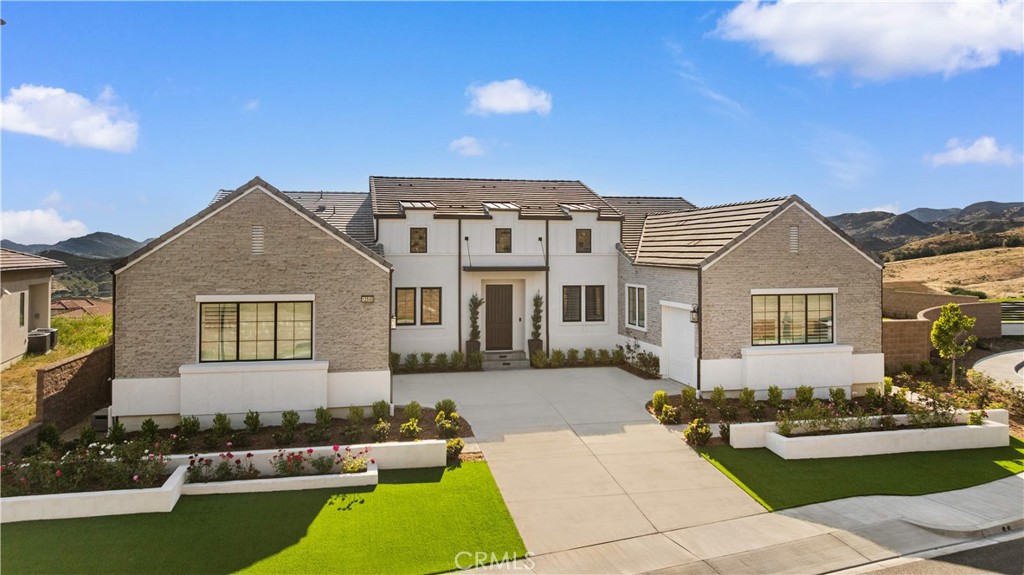 a front view of a house with a garden and yard