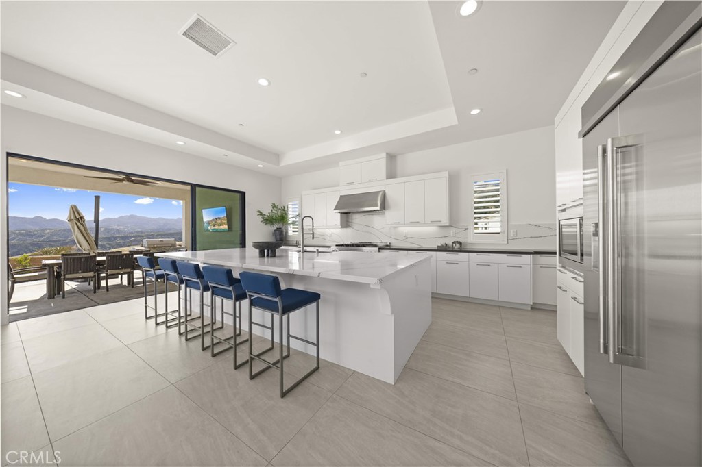 12545 North Silver Spur Court Porter Ranch, CA 91326 - Photo 11 of 22 a kitchen with a table chairs refrigerator and cabinets