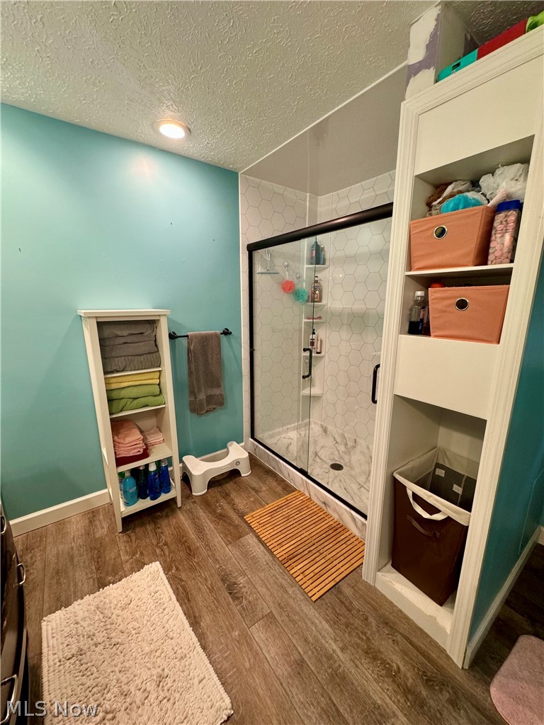 7199 Murray Ridge Road Elyria, OH 44035 - Photo 20 of 29 Bathroom with hardwood / wood-style floors, walk in shower, and a textured ceiling