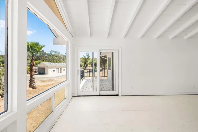 an empty room with a window and a ceiling fan