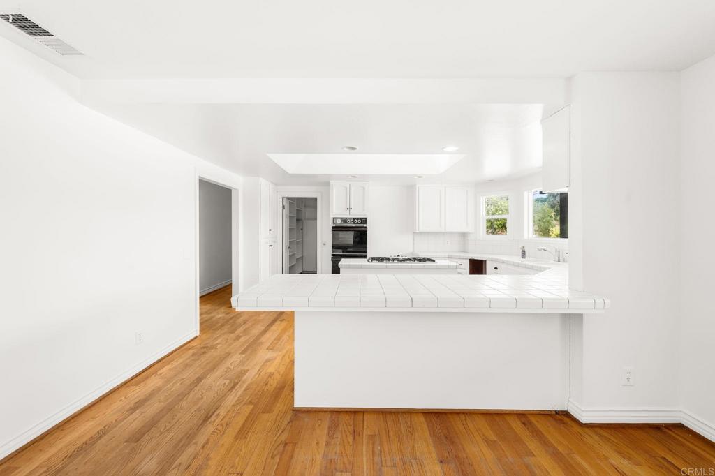 758 Verde Avenue Fallbrook, CA 92028 - Photo 37 of 71 a large white kitchen with kitchen island white cabinets and wooden floor