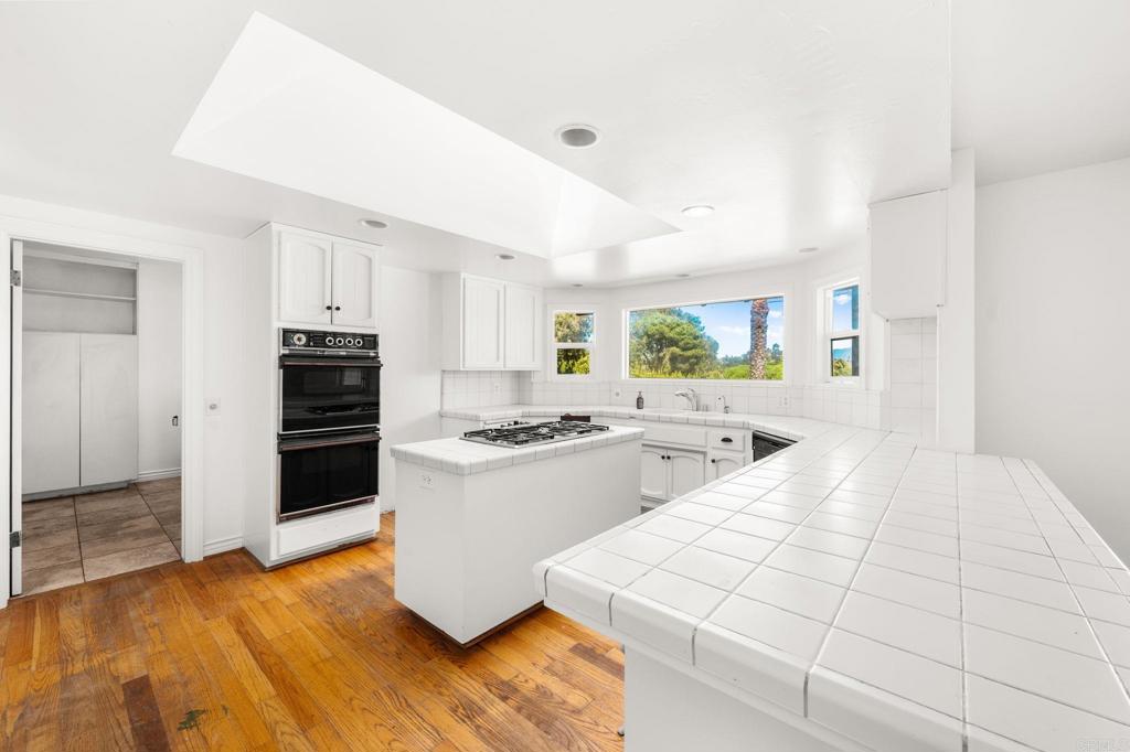 758 Verde Avenue Fallbrook, CA 92028 - Photo 38 of 71 a kitchen with stainless steel appliances wooden floor and a refrigerator