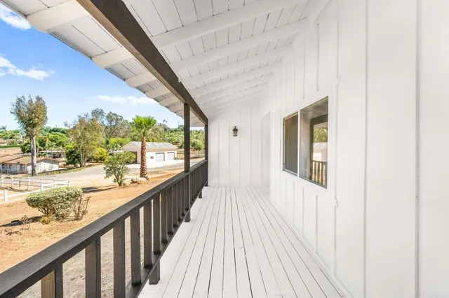 a view of balcony with wooden floor and fence