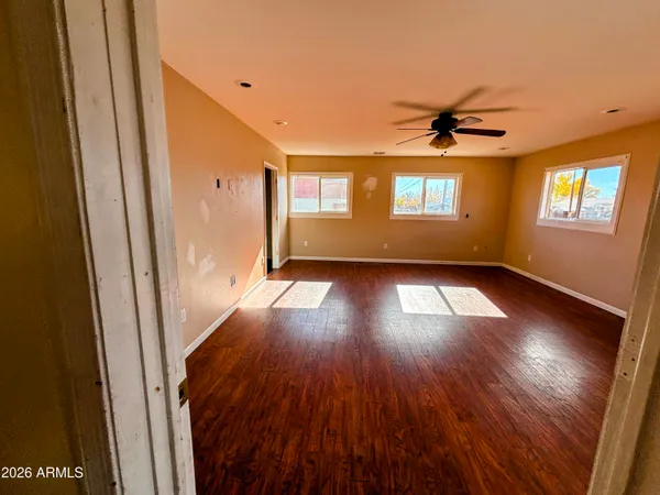 a view of empty room with wooden floor