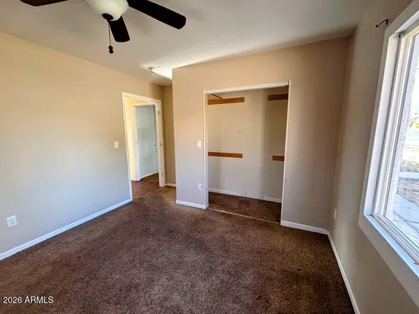 an empty room with closet and windows