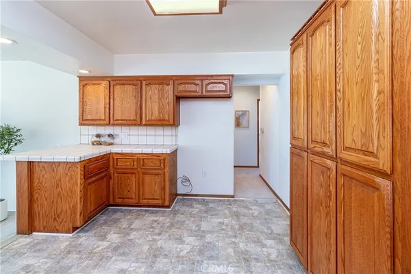 a view of kitchen with granite countertop cabinets and window
