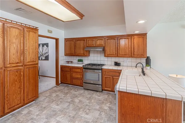 a kitchen with a refrigerator sink and cabinets