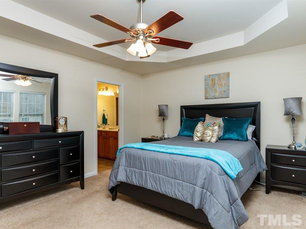 8321 Pilots View Drive Raleigh, NC 27617 - Photo 16 of 25 a bedroom with a bed and a chandelier