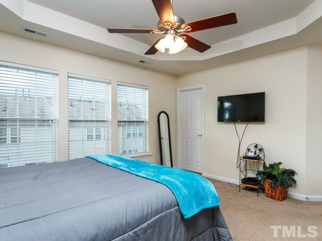 8321 Pilots View Drive Raleigh, NC 27617 - Photo 17 of 25 a bedroom with a bed a flat screen tv and a chandelier