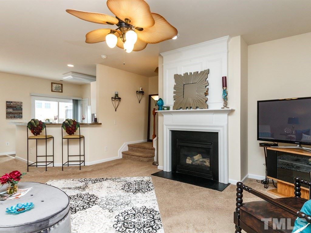 8321 Pilots View Drive Raleigh, NC 27617 - Photo 8 of 25 a living room with furniture a flat screen tv and a fireplace