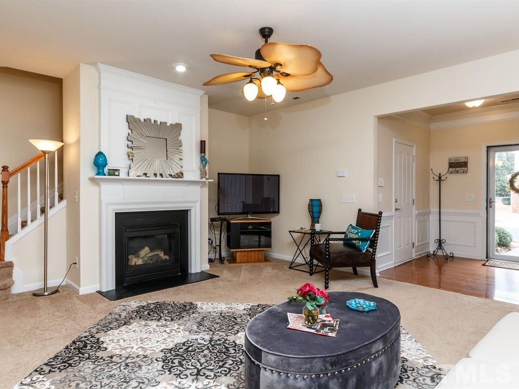 8321 Pilots View Drive Raleigh, NC 27617 - Photo 9 of 25 a living room with furniture a fireplace and a flat screen tv
