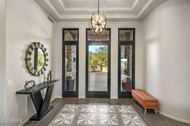 a dining room with furniture a chandelier and wooden floor