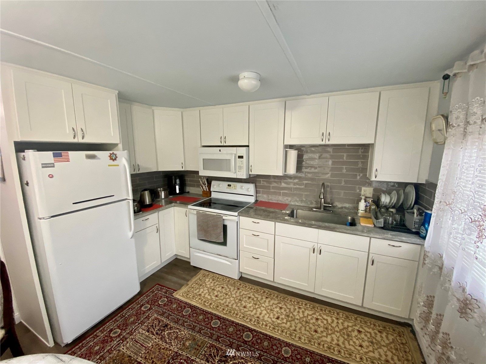 15232 Southeast 272nd Street, Unit 99 Kent, WA 98042 - Photo 7 of 15 a kitchen with white cabinets sink and white appliances