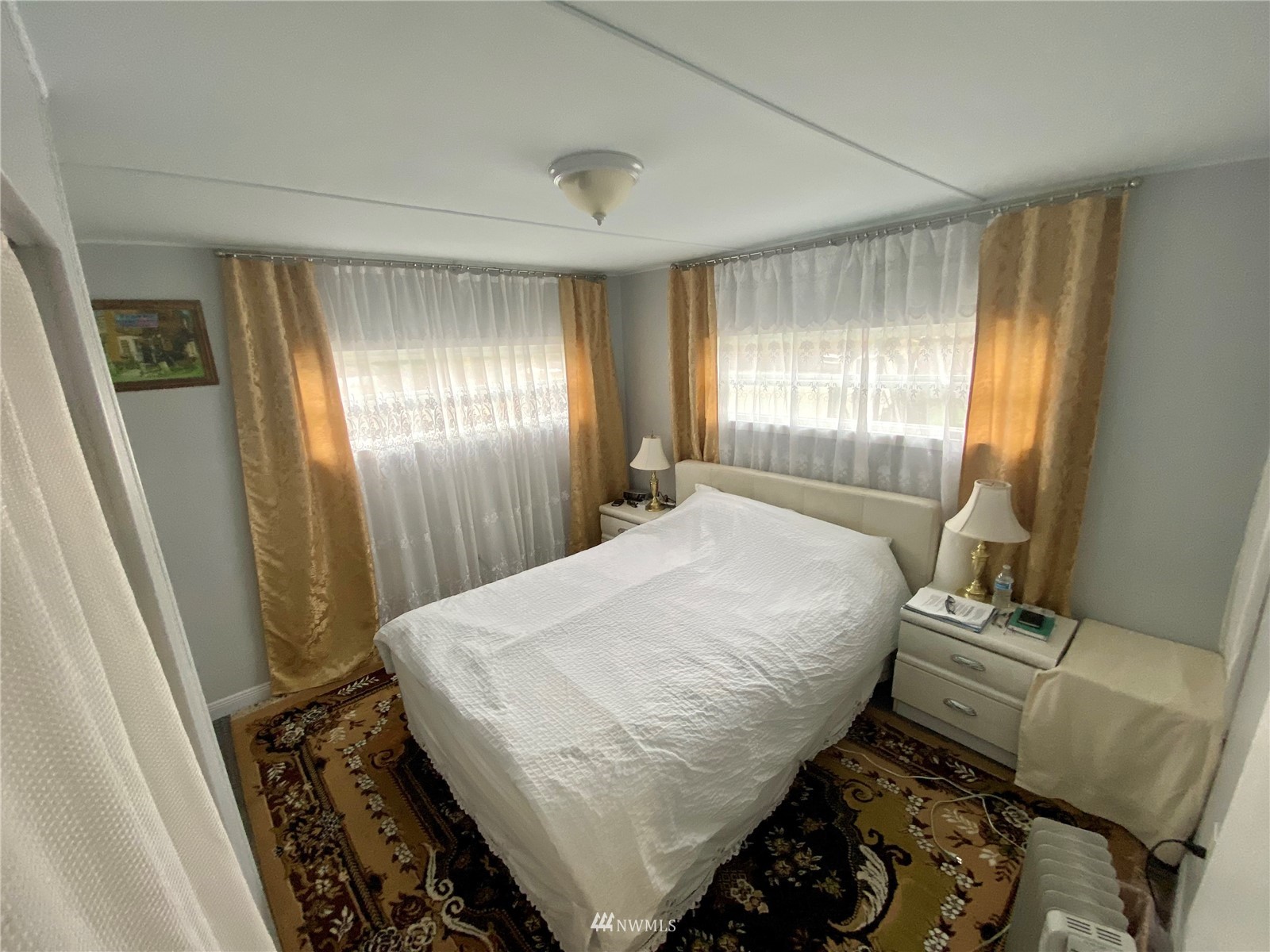 15232 Southeast 272nd Street, Unit 99 Kent, WA 98042 - Photo 9 of 15 a bed sitting in a spacious bedroom next to a window
