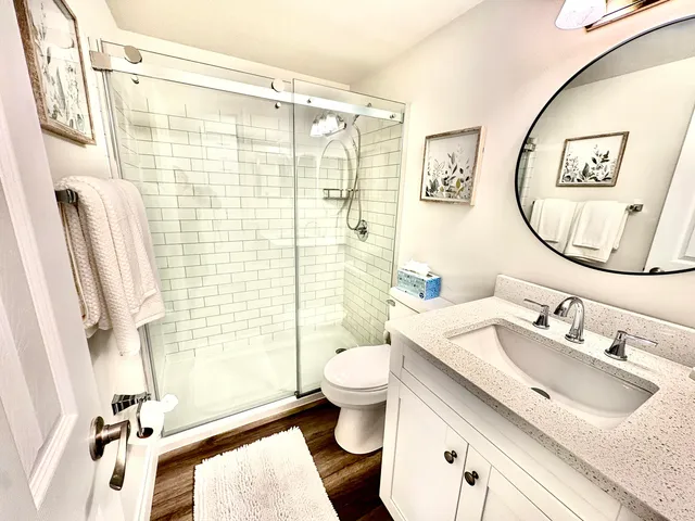 a bathroom with a sink vanity mirror and toilet