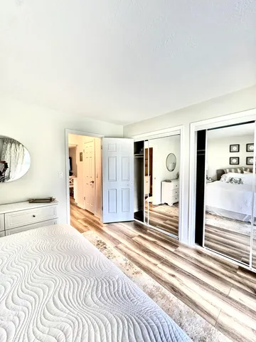 a bedroom with a bed and a large mirror on the dresser