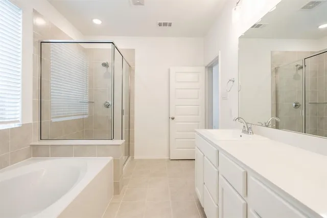 a bathroom with a tub sink and mirror