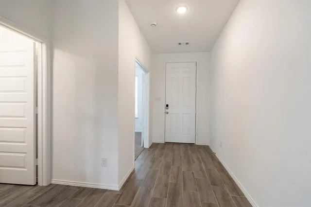 a view of a hallway with wooden floor
