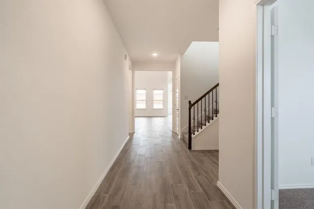 a view of a hallway with wooden floor