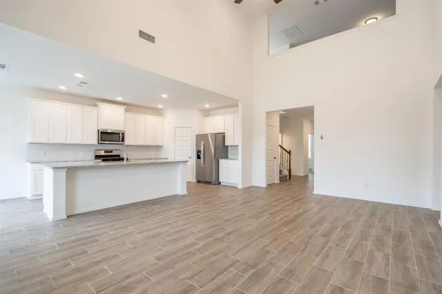 a view of kitchen with granite countertop stainless steel appliances refrigerator and microwave