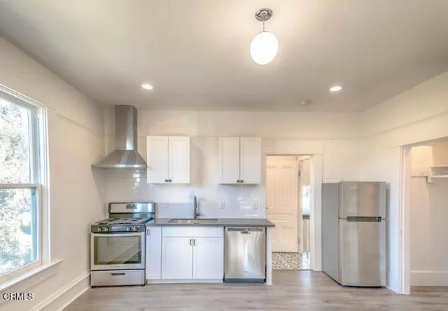 a kitchen with a sink stainless steel appliances and window