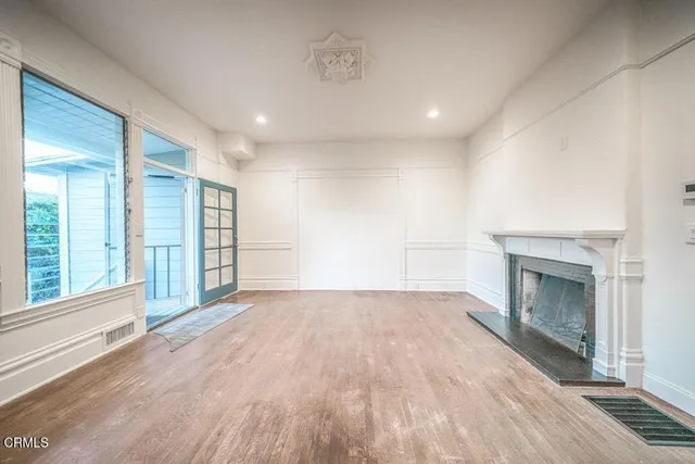 a view of empty room with wooden floor and fireplace