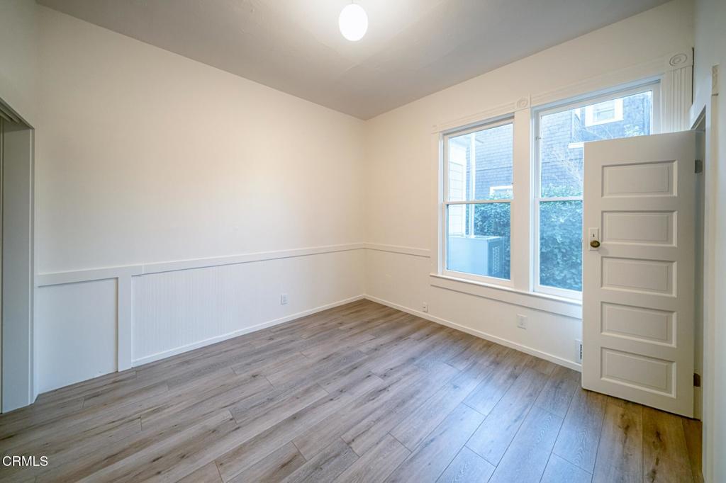 1416 Bath Street Santa Barbara, CA 93101 - Photo 15 of 22 an empty room with wooden floor and windows