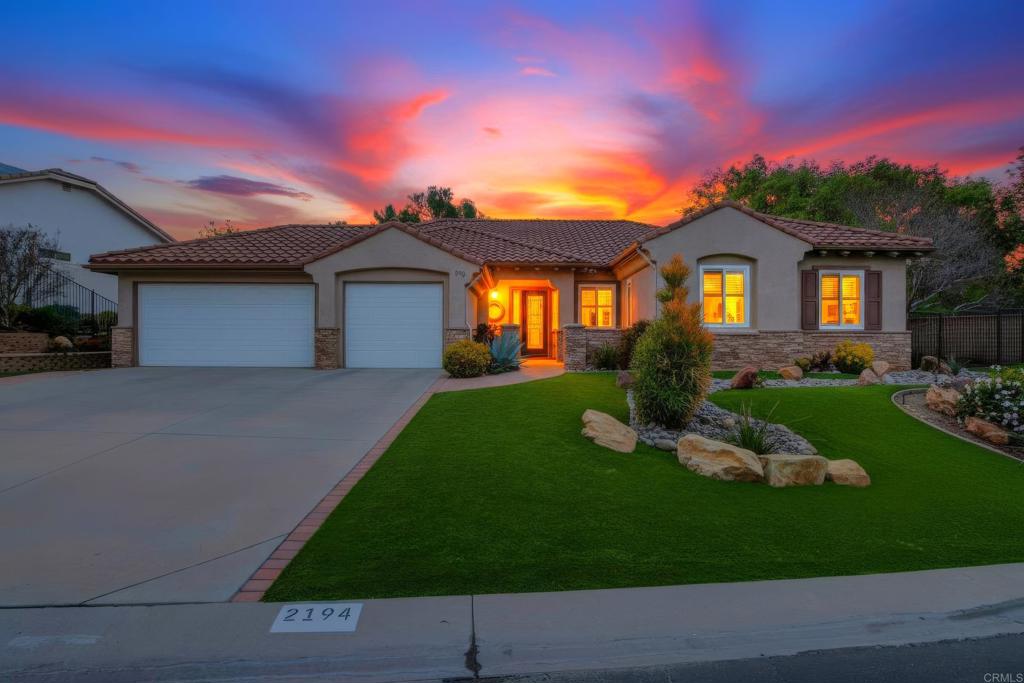 a front view of a house with a garden and yard