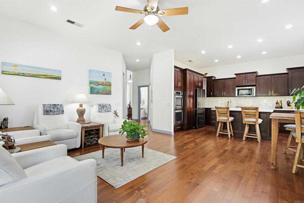 2194 Stone Castle Fallbrook, CA 92028 - Photo 18 of 60 a living room with furniture kitchen view and a wooden floor