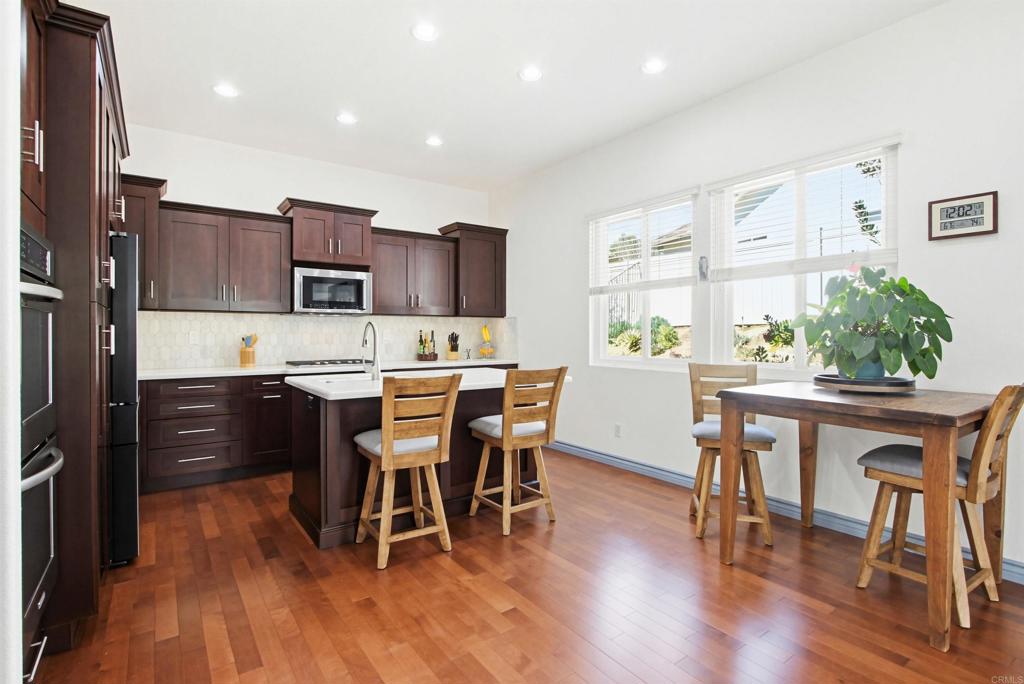 2194 Stone Castle Fallbrook, CA 92028 - Photo 19 of 60 a kitchen with a table chairs refrigerator and microwave
