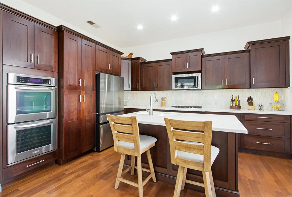 2194 Stone Castle Fallbrook, CA 92028 - Photo 20 of 60 a kitchen with a table chairs refrigerator and microwave
