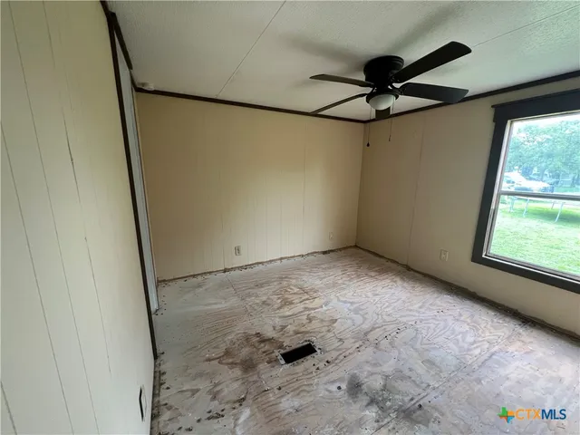 a view of a room with a ceiling fan and a window