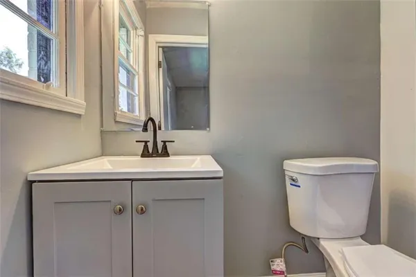 a bathroom with a toilet a sink and mirror