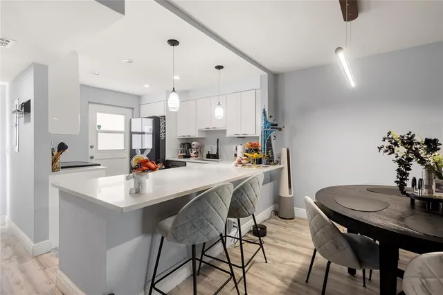 a kitchen with appliances a sink and a dining table