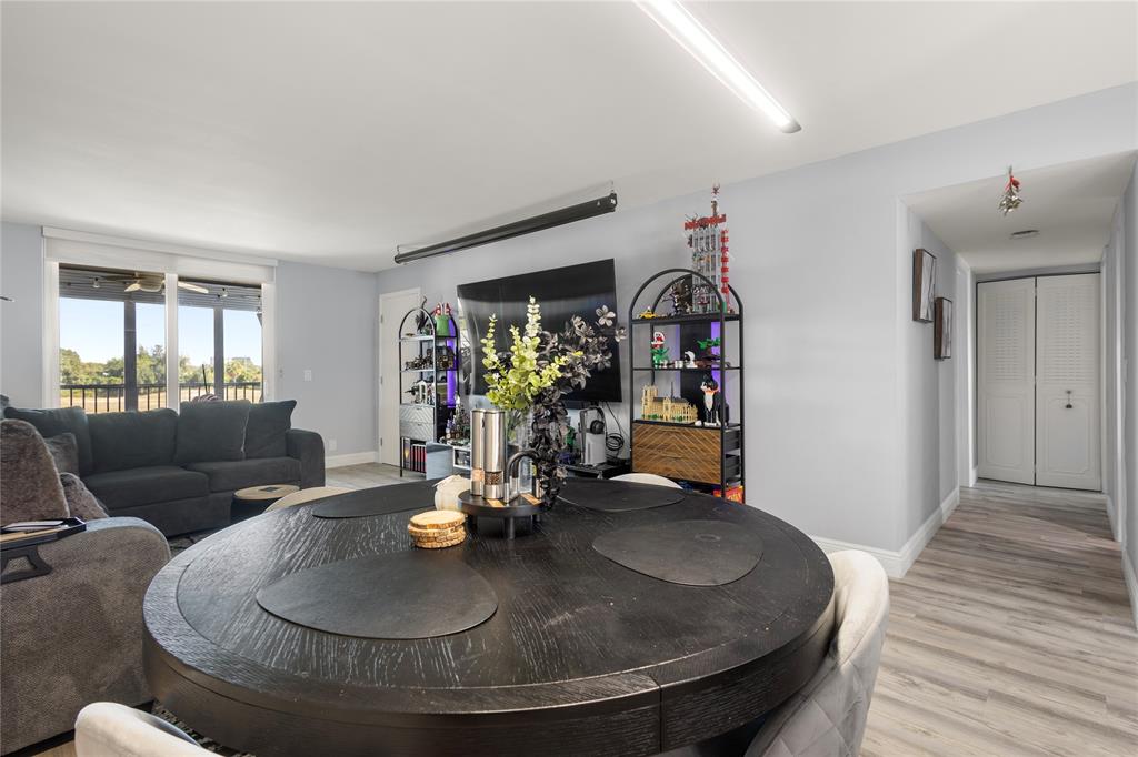 5500 Northwest 2nd Avenue, Unit 316 Boca Raton, FL 33487 - Photo 12 of 31 a dining room with wooden floor a chandelier a wooden table and chairs