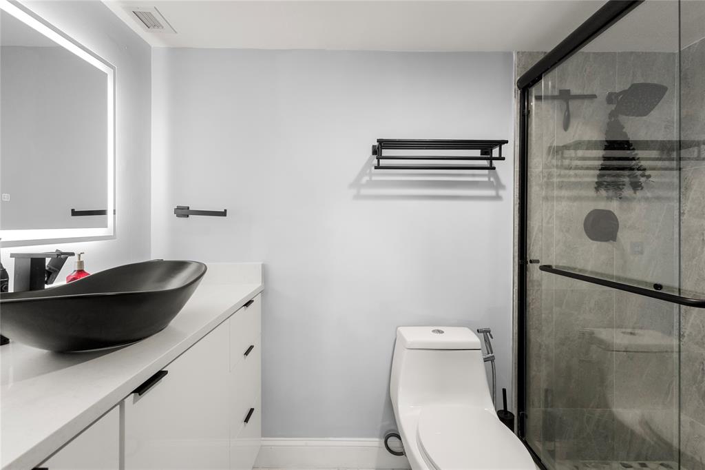 5500 Northwest 2nd Avenue, Unit 316 Boca Raton, FL 33487 - Photo 17 of 31 a bathroom with a sink a toilet and a shower