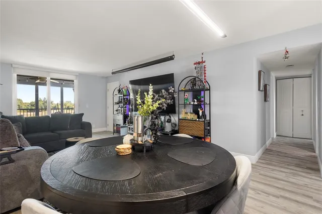 a dining room with wooden floor a chandelier a wooden table and chairs