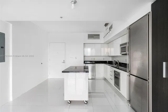 a kitchen with white cabinets and stainless steel appliances