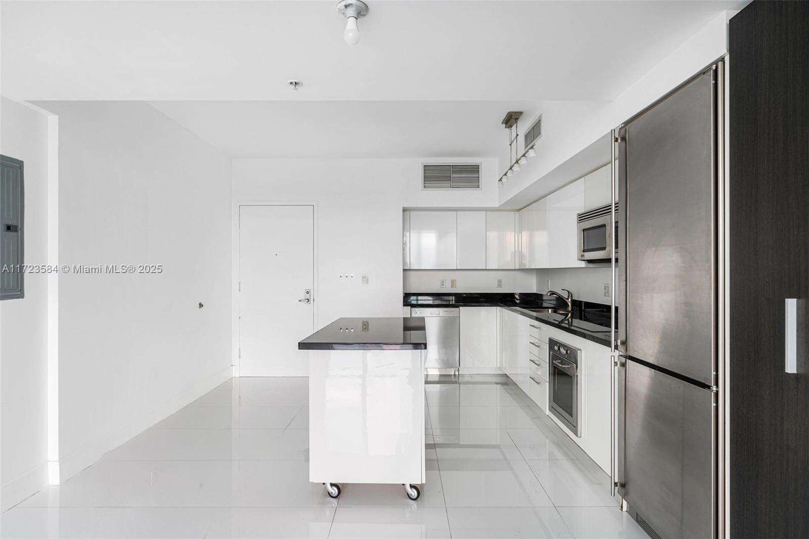 a kitchen with white cabinets and stainless steel appliances