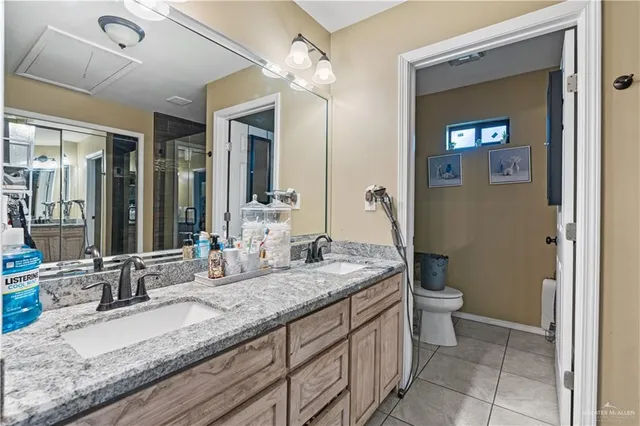a bathroom with a granite countertop sink mirror and toilet